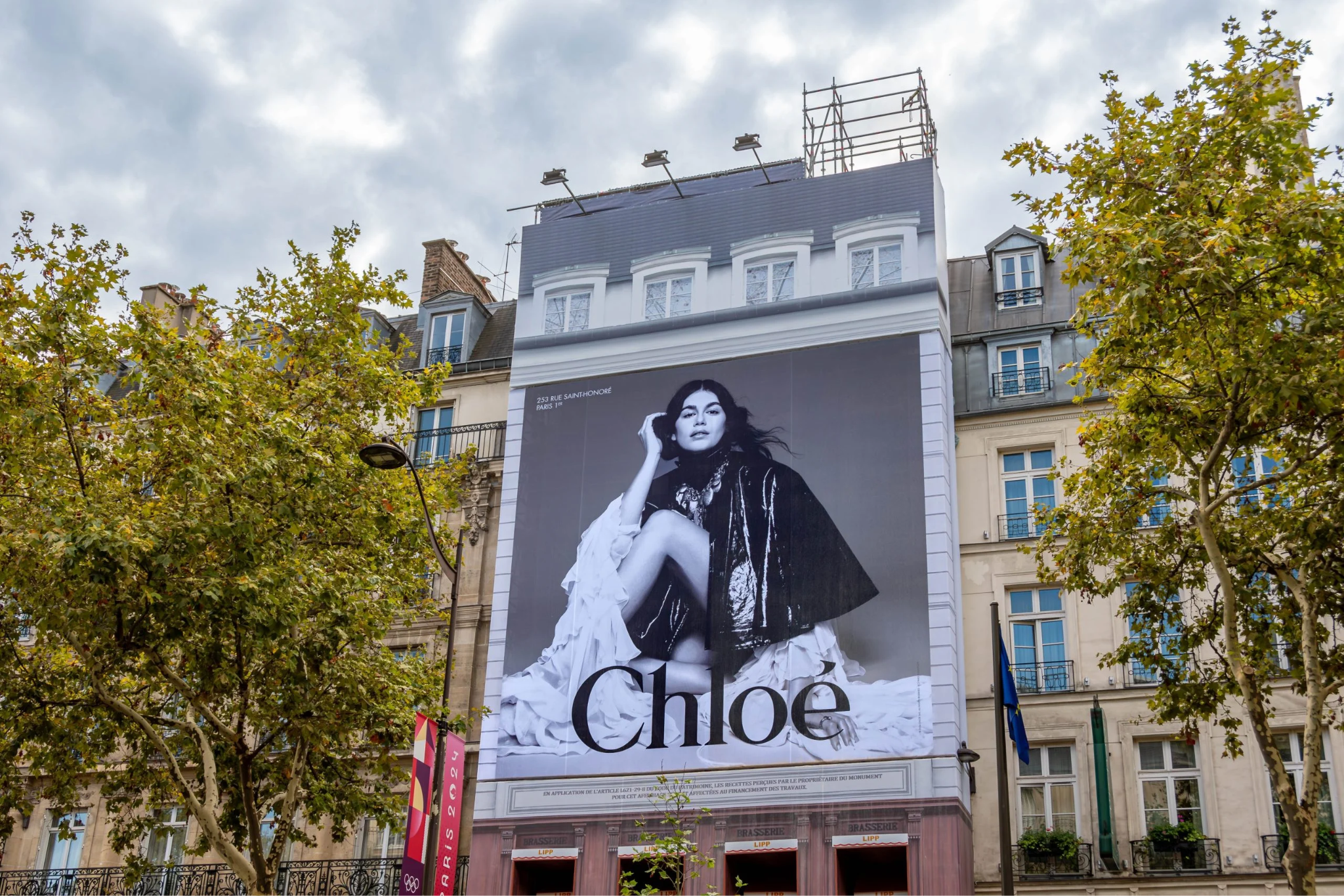 Large black-and-white Chloé fashion advertisement covering the façade of a building in a city street.