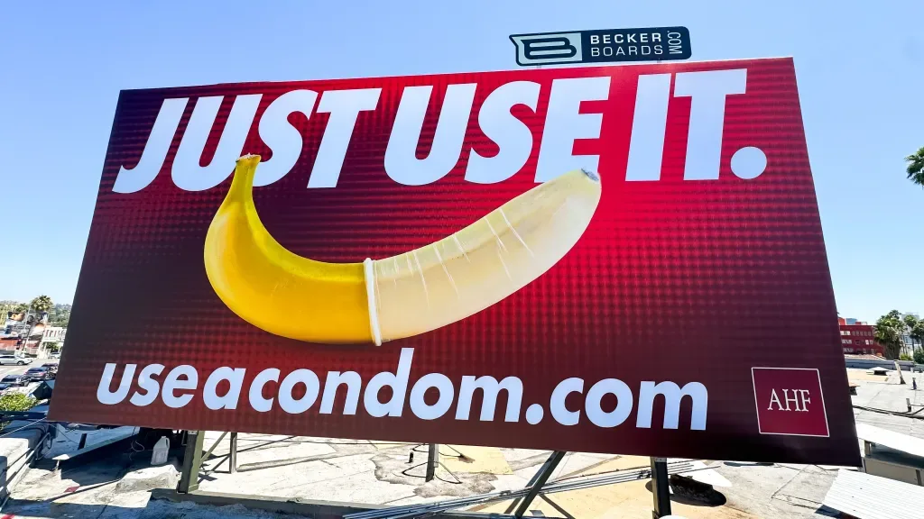Billboard kampanii „Just Use It” z bananem i hasłem zachęcającym do używania prezerwatyw