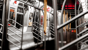 Interior of a subway train with advertising panels and passenger seating